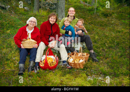 Famille avec des paniers de champignons dans la forêt Banque D'Images