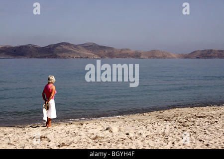 UNE FEMELLE SOLITAIRE REGARDE VERS L'ÎLE DE MER DE KOS. Banque D'Images