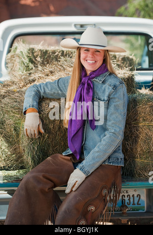 Cowgirl assis sur l'arrière du chariot Banque D'Images