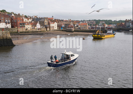 Un petit bateau entrant dans l'avant-port de Whitby. Banque D'Images