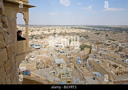 Femme contemplant la ville touristique de la chambre d'un balcon. Jaisalmer. Le Rajasthan. L'Inde Banque D'Images