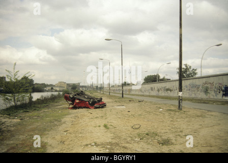 Une voiture est renversée et abandonné près du mur de Berlin en mai 1991 peu avant l'effondrement de l'Union soviétique. Banque D'Images