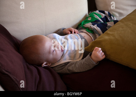 Six mois du garçon endormi sur le canapé. Londres, Angleterre Banque D'Images