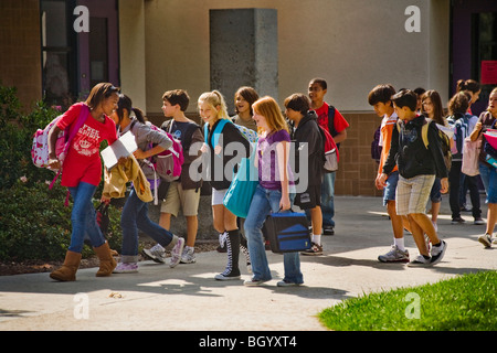 Un groupe multiethnique de Californie middle school cross leur campus entre les classes. Banque D'Images