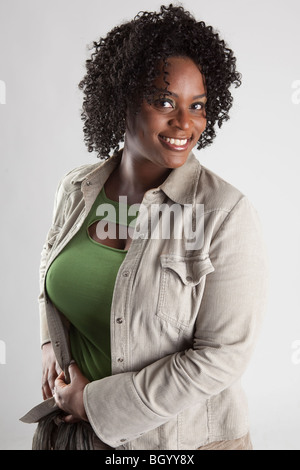 Heureux et jolie femme noire portant un mignon équipement dans le studio Banque D'Images