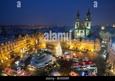 Aperçu de la tour de l'horloge du Marché de Noël à la place de la vieille ville avec l'église Notre Dame de Tyn avant dans la neige Banque D'Images