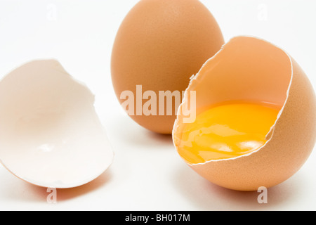 Ensemble unique d'oeufs de poules avec oeufs fêlés montrant œuf isolés contre fond blanc Banque D'Images