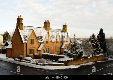 Quatre maisons d'aumône en haut de Cow Lane, Bramcote, Nottingham. Ils sont indiqués en hiver avec de la neige au sol. Banque D'Images