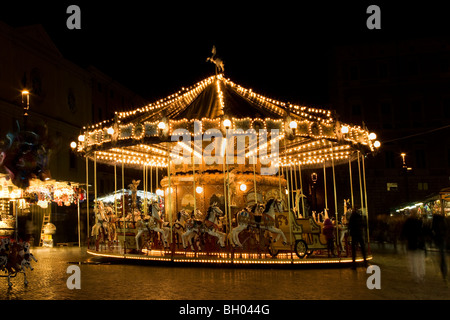 Photo de nuit d'un carrousel de foire à la place Navone à Rome Italie avec stands colorés pour la fête de la Befana Banque D'Images