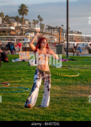 Un heureux hula hoop enthusiast se joint à une session' 'Hoopnosis en fin d'après-midi à Laguna Beach, CA. Remarque signe. Banque D'Images