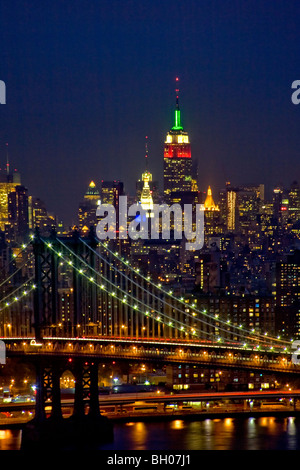 L'éclat des lumières au crépuscule dans le centre de Manhattan et de New York City's Manhattan Bridge. Remarque L'Empire State Building dans le centre droit. Banque D'Images