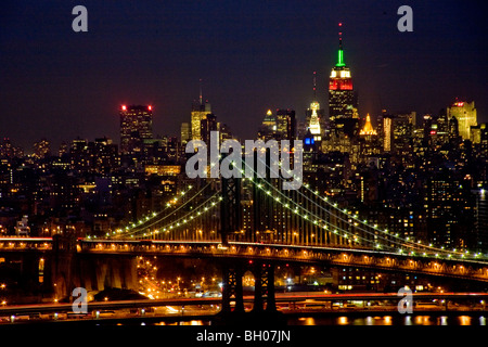 L'éclat des lumières au crépuscule dans le centre de Manhattan et de New York City's Manhattan Bridge. Remarque L'Empire State Building dans le centre droit. Banque D'Images