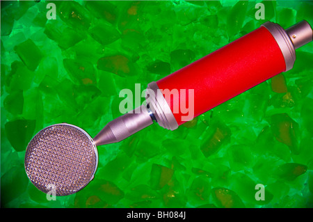 Microphone rouge assis sur un lit de glace verte. Logos déposés pour permettre pour toute utilisation. Banque D'Images