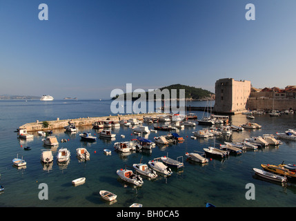 Le Port de Dubrovnik avec de petits bateaux de pêche et grand bateau de croisière amarré dans la baie Croatie Banque D'Images