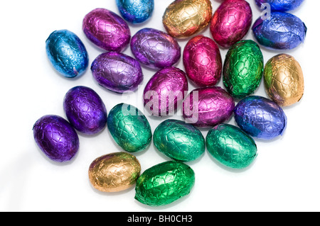 Une petite sélection d'oeufs de Pâques au chocolat mini colorés sur fond blanc Banque D'Images