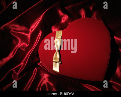 Red Heart-shaped gift box avec un archet d'or Banque D'Images