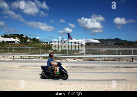 Man riding scooter près de Continental Airlines 737 sur le bitume Banque D'Images