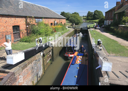 Deux narrowboats émergeant de Braunston Verrouillage du fond, un double verrouillage sur le Grand Union Canal, Northamptonshire Banque D'Images