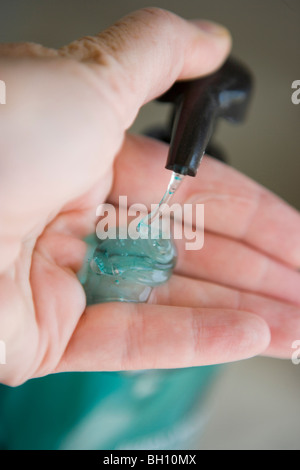 Pompage d'une personne pour les mains gel dans sa main close up Banque D'Images