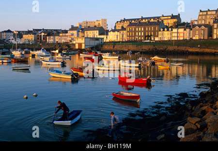 Les garçons l'aviron dans le port dans la soirée, Portrush, comté d'Antrim, Irlande, Europe Banque D'Images