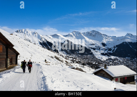 Couple en train de marcher sur un chemin au-dessus de la station de Verbier, Valais, Suisse Banque D'Images