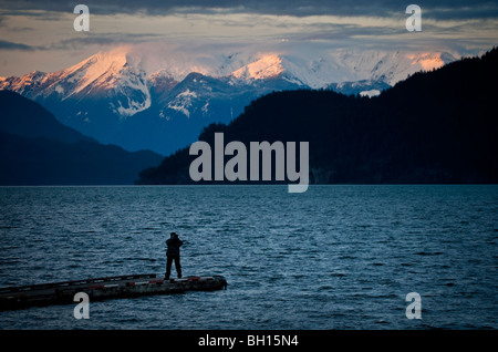 Harrison Lake, British Columbia, Canada. Un moment la prise de photo se présente comme le coucher de soleil sur des montagnes enneigées. Banque D'Images