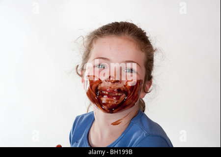 Little girl smiling grâce au chocolat visage couvert Banque D'Images