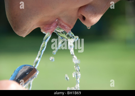 L'homme asiatique de boissons fontaine à eau dans le parc Assiniboine, Winnipeg, Manitoba, Canada Banque D'Images