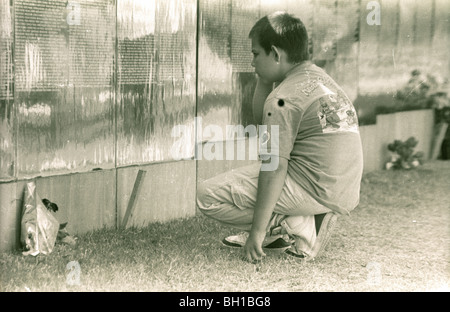 Garçon à la recherche d'un nom. La guerre du Vietnam déménagement memorial wall rend un arrêt à Porterville, Californie en 1988. Banque D'Images