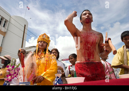 Le Festival Végétarien de Krabi, Thaïlande, implique une procession rue parfois sanglantes. Cet homme s'est coupé avec une hache. Banque D'Images