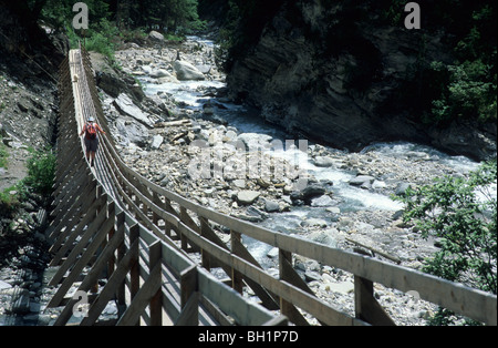 Femme avec sac à dos sur un pont suspendu très haut dans la vallée Val Sinestra, Silvretta, Silvretta, Unterengadin, Engadine, gris Banque D'Images