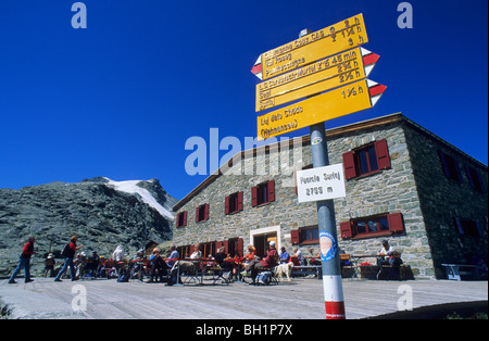 Panneau Suisse jaune en face de la terrasse du chalet de montagne Fuorcla Surlej-Huette avec beaucoup de randonneurs se reposer, Fuorcla Surlej, Berne Banque D'Images