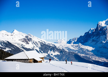 Les skieurs de l'arrière-pays près d'un chalet de montagne, Maennlichen, Grindelwald, Oberland Bernois, Canton de Berne, Suisse Banque D'Images