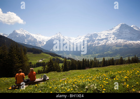 Les randonneurs se reposant à Bussalp (1800 m), vue de face nord de l'Eiger (3970 m), Grindelwald, Oberland Bernois (Highlands), Canton de Berne Banque D'Images