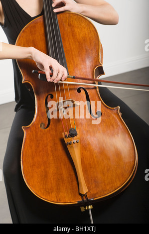 Mid section of woman bowing un violoncelle Banque D'Images