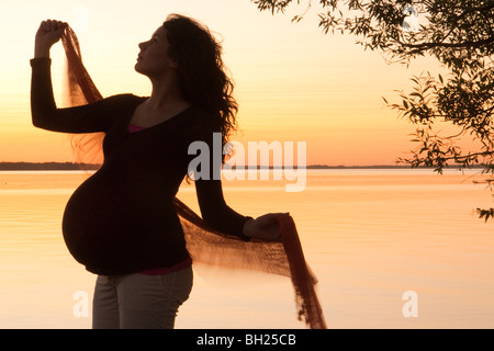 Silohuette de femme enceinte au coucher du soleil, Clear Lake, Manitoba, Canada Banque D'Images