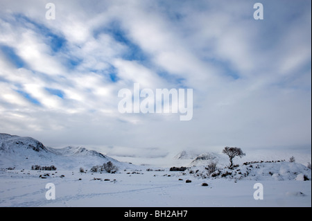 La recherche à travers un frozen lochan nah-achlaise des sommets de la chaîne de montagnes Blackmount en hiver. Banque D'Images