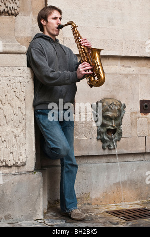 Jeune homme jouant du saxophone dans les rues de Paris Banque D'Images