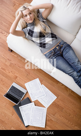 High angle view of a young woman frustré tout en faisant de la paperasserie. Tir vertical. Banque D'Images