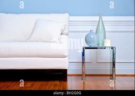 Portrait de la table blanche et petite table avec des vases, dans un salon avec un plancher de bois. Format horizontal. Banque D'Images