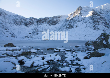 Ogwen Valley du Nord du Pays de Galles Conwy Janvier à l'ensemble du frozen Llyn Idwal vers Cuisine Devils sur un jour des hivers enneigés du Parc National de Snowdonia Banque D'Images