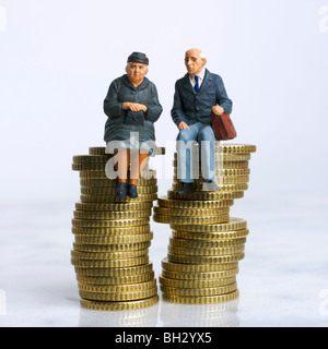 Personnes âgées / couple (figurines) - assis sur une pile de pièces de monnaie - épargne / épargne / factures / financier / investissement / concept de pension Banque D'Images
