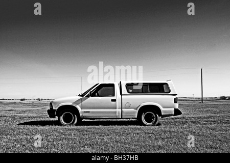 Ancien modèle 1994 Chevrolet pick up se tient dans le contraste dramatique à la fraîche, propre, claire atmosphère de la vaste terre d'herbe Banque D'Images