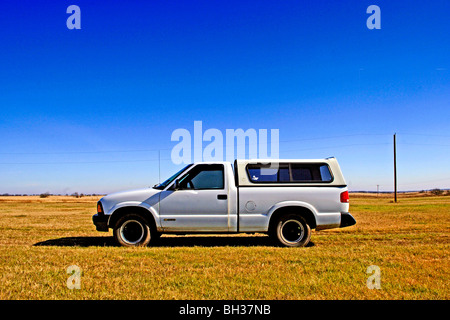 Ancien modèle 1994 Chevrolet pick up se tient dans le contraste dramatique à la fraîche, propre, claire atmosphère de la vaste terre d'herbe Banque D'Images