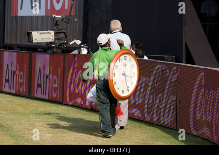 Un Indien porte un grand réveil dans le champ extérieur de la Kotla Stadium à New Delhi, en Inde. Photo par James Boardman Banque D'Images