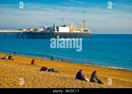 Les gens sur la plage avec la mer en arrière-plan la jetée de Brighton Angleterre Angleterre Europe Banque D'Images