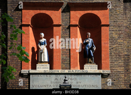 La façade d'un dix-huitième siècle, l'école Saint Jean de Wapping, fondée 1695, érigée en 1760. Deux statues d'enfants. Banque D'Images