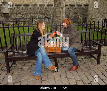 Jeune couple ayant un pique-nique romantique de champagne et fraises. Banque D'Images