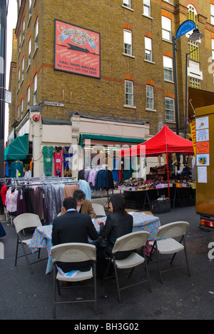 Les tableaux à côté de stands de nourriture à jupon Lane market East London England UK Europe Banque D'Images