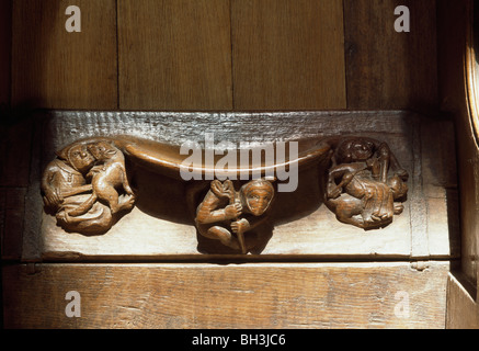 La cathédrale de Winchester, Hampshire. Dans le Misericord quire, le filage de la laine et l'homme montrant l'attaque d'animaux Banque D'Images